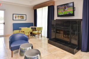 ein Wohnzimmer mit Kamin und Fernseher in der Unterkunft Holiday Inn Express & Suites San Antonio South by IHG in San Antonio