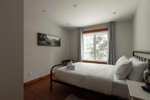 une chambre avec un lit blanc et une fenêtre dans l'établissement Pool - Kid Game Room - HotTub, à Saint-Faustin–Lac-Carré