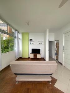 ein großes Zimmer mit einem Bett und einem Fernseher in der Unterkunft Apartamento no Corredor da Vitoria in Salvador