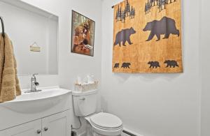 a bathroom with a toilet and a towel on the wall at Cozy Poconos Cabin in Blakeslee +39 photos