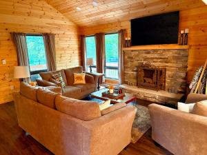 a living room with two couches and a fireplace at Cozy Poconos Cabin in Blakeslee
