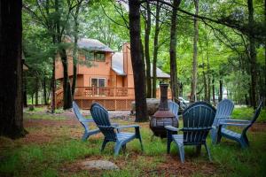 a group of chairs sitting in front of a house at Cozy Poconos Cabin in Blakeslee