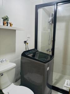 a bathroom with a shower and a toilet at Norman Condominium Unit Rental Sea View in Dumaguete