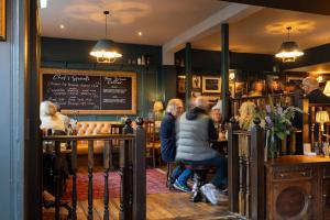 a group of people sitting at a bar in a restaurant at The Westgate in Winchester