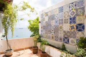 a room with a tile wall with a view of the ocean at Apartamento no Corredor da Vitoria in Salvador