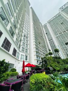 een groep tafels en stoelen voor een gebouw bij RBR Lux at Novotel Manila Hotel Residences Acqua in Manilla