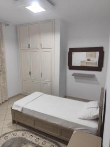 a bedroom with a bed and a mirror on the wall at immeuble brini in Kairouan