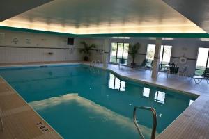 a large swimming pool with blue water in a building at Holiday Inn Express and Suites Dimondale-Lansing 