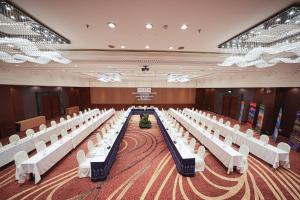 乌隆他尼Centara Udon的一间摆放着一排排白色椅子的大房间 更多101张照片