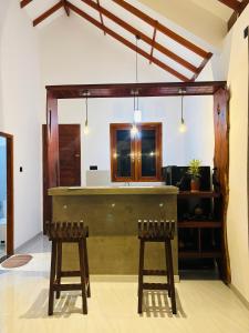 a bar in a room with two stools at Rock Harmony Villa in Hikkaduwa