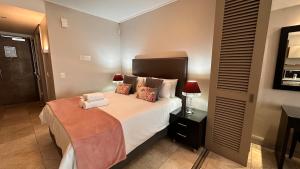 Un dormitorio con una cama y una mesita de noche con una lámpara. en Luxury Waterfront Studio with Canal Views, en Ciudad del Cabo