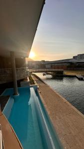 una piscina al lado de un edificio junto al agua en Luxury Waterfront Studio with Canal Views, en Ciudad del Cabo