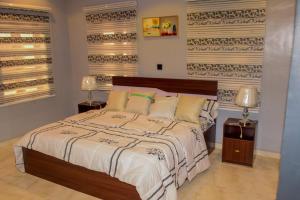 ein Schlafzimmer mit einem großen Bett und zwei Lampen in der Unterkunft Gods Heritage Apartments and properties nig ltd 