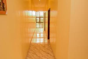 ein Flur mit gelben Wänden und einer Tür mit einer Flurlänge in der Unterkunft Gods Heritage Apartments and properties nig ltd 