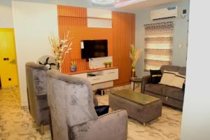 ein Wohnzimmer mit Sofa und Fernseher in der Unterkunft Gods Heritage Apartments and properties nig ltd 
