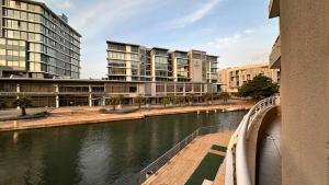 Un puente sobre un río en una ciudad con edificios. en Luxury Waterfront Studio with Canal Views, en Ciudad del Cabo