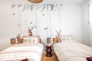 two beds in a bedroom with white walls at Rodern - Le Cocon des vignes in Rodern
