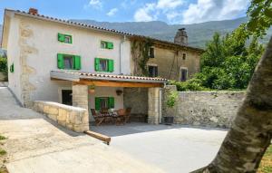 a house with green shutters and a patio at House Casa Della Nonna in Kršan