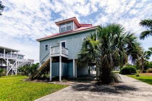 a house on the beach with a palm tree at Cupola House in Edisto Island
