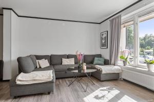 a living room with a gray couch and a table at Xeneith Private Room in Kallinge