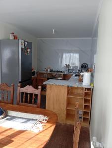 a kitchen with a table and a refrigerator at Cabaña con vista al mar in Tomé