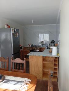 a kitchen with a refrigerator and a kitchen table at Cabaña con vista al mar in Tomé +3 photos