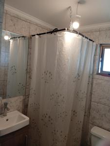 a bathroom with a shower curtain and a sink at Cabaña con vista al mar in Tomé