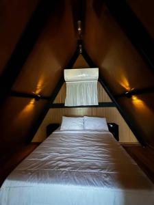 a bedroom with a bed in a triangular room at Cabana Fé Miguel Pereira Com Ofuro e Por do Sol in Miguel Pereira