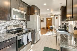 Una cocina con electrodomésticos de acero inoxidable y gabinetes de madera. en Prime Belmar Access! Updated Unit with Office and Yard, en Lakewood