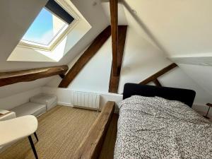 a attic bedroom with a bed and a window at Perfect pied-à-terre in Dijon in Dijon