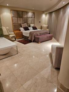 a large bedroom with a bed and a tub in it at The Pearls of Umhlanga, or Oceans Apts in Durban