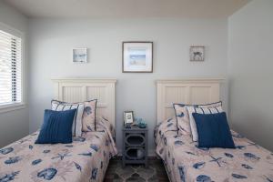 two beds sitting next to each other in a bedroom at Club Cottage 824 - CLARITY in Edisto Beach +22 photos