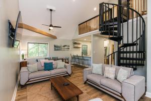 a living room with two couches and a staircase at Edisto Echo in Edisto Beach