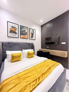 a bedroom with a large bed with yellow sheets at UV Residence in Ikota
