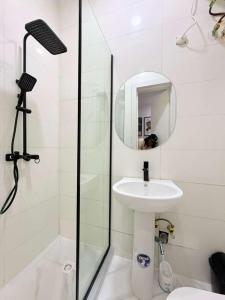 a white bathroom with a sink and a mirror at UV Residence in Ikota +16 photos