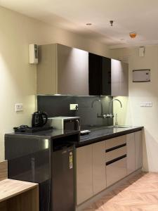 a kitchen with a black counter top and stainless steel appliances at Elite Stay near Expo Mart Delta 1 metro in Greater Noida