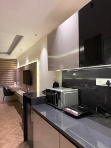 a kitchen with a counter top with a microwave at Elite Stay near Expo Mart Delta 1 metro in Greater Noida +16 photos