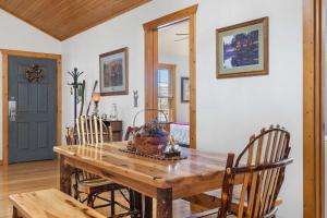 a dining room with a wooden table and chairs at Grey Moose Lodge with Amenities Access in Branson West +18 photos