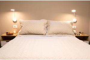 a bedroom with a white bed with two lamps at Casita Médano in El Médano