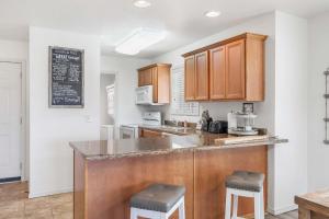 a kitchen with wooden cabinets and a counter with stools at Retreat at Par Lane - Family friendly condo in Branson West