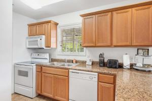 a kitchen with wooden cabinets and a white dishwasher at Retreat at Par Lane - Family friendly condo in Branson West