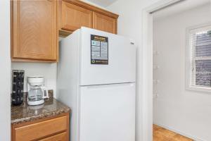 a white refrigerator in a kitchen with wooden cabinets at Retreat at Par Lane - Family friendly condo in Branson West