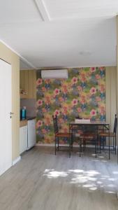 ein Esszimmer mit einem Tisch und Stühlen vor einer Wand in der Unterkunft La Comarca Tinyhouse Monoambiente in Puerto Iguazú