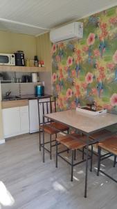 a kitchen with a table and chairs with a floral wall at La Comarca Tinyhouse Monoambiente in Puerto Iguazú +4 photos