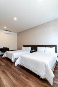 メデジンにあるBest Western Plus Hotel Sandiegoの木製の床の部屋にベッドが2つあります