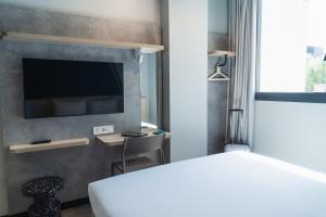 a bedroom with a bed and a tv on a wall at ibis budget Madrid Albasanz in Madrid