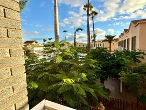 a view of a city with palm trees and buildings at Oasis Lemon in Maspalomas