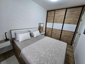 a bedroom with a bed and a large window at Stan na dan Platinum in Zrenjanin