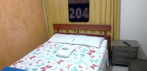 a bedroom with a bed with a flowery comforter at Pousada do Farol Bar e Restaurante in Vila Velha