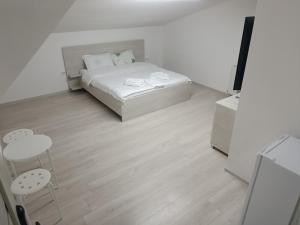 ブカレストにあるMax Night Dreamsの白いベッドルーム(ベッド1台、椅子2脚付)